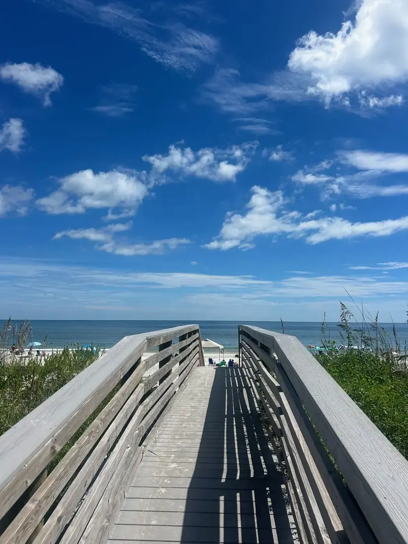 Boardwalk to the beach under a blue sky